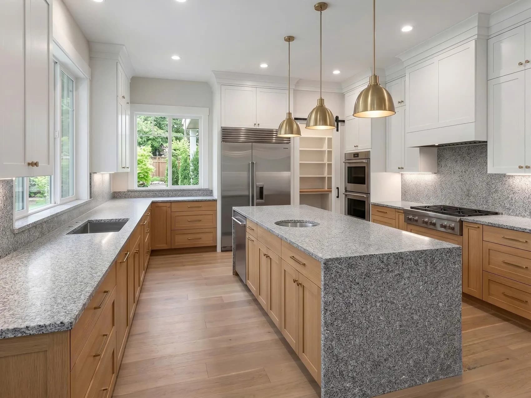 Kitchen with a gray speckled granite island and wood cabinets