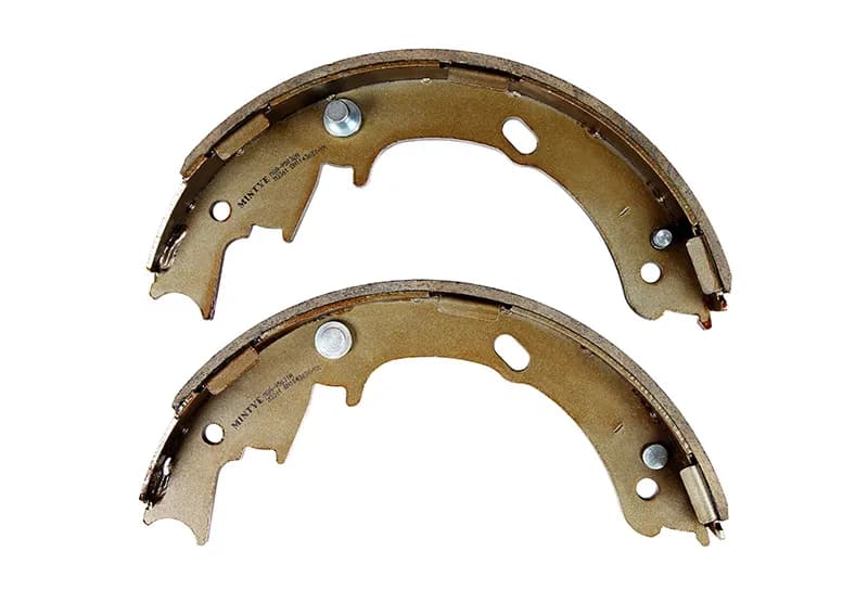 Pair of brake shoes with friction linings on a white background