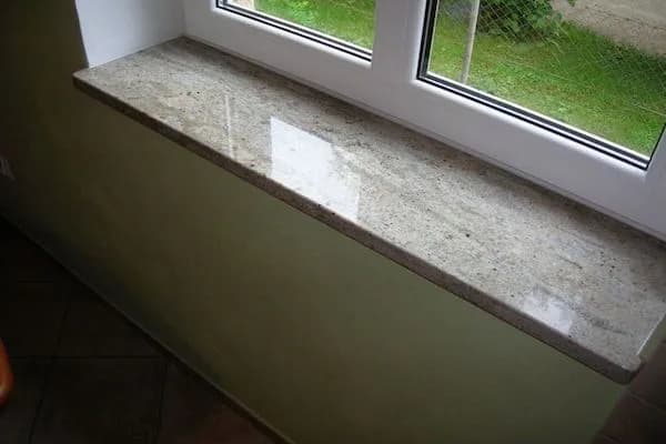 Polished granite window sill under a window