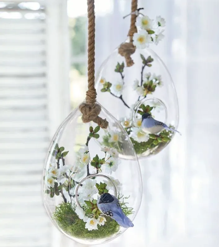 Hanging clear glass vase with flowers and a bird
