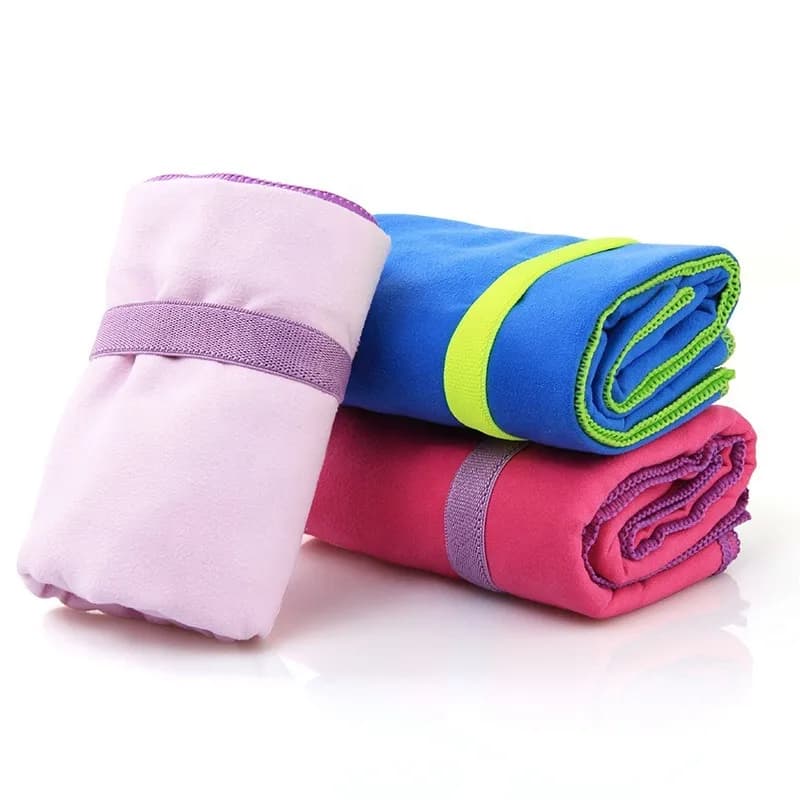 Rolled sports towels in pink, blue and purple with elastic bands